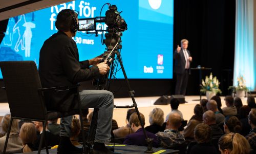 Kameraman filmar stor scen med publik